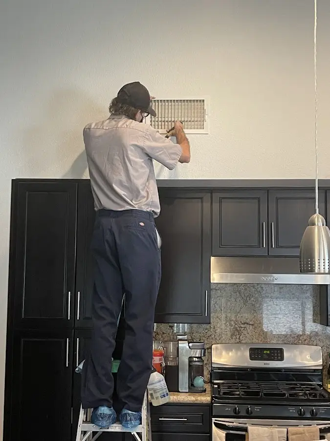 Technician inspecting an air vent during HVAC service in Hamptonburgh